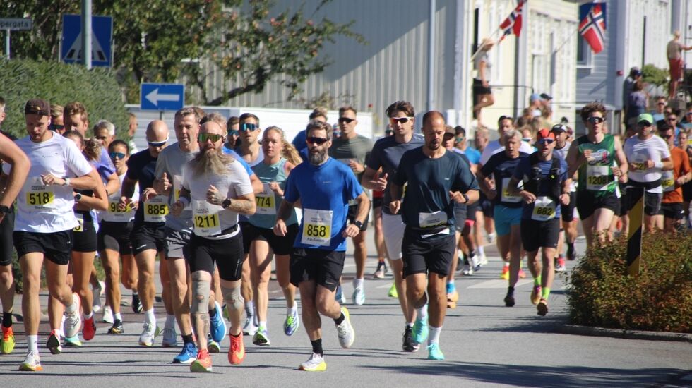 Halvmaratonfeltet omgivet af mennesker, blomster og træhuse