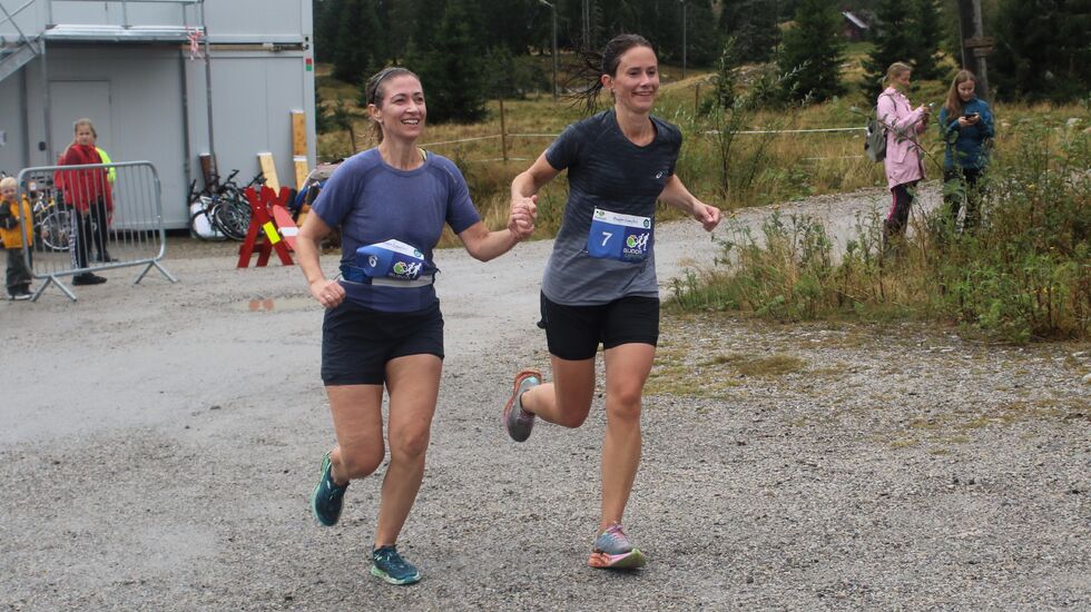 Caroline Nylund Øvsthus (til venstre) og Åse Sigrid Torp hånd i hånd mot mål på sin 10 km. 