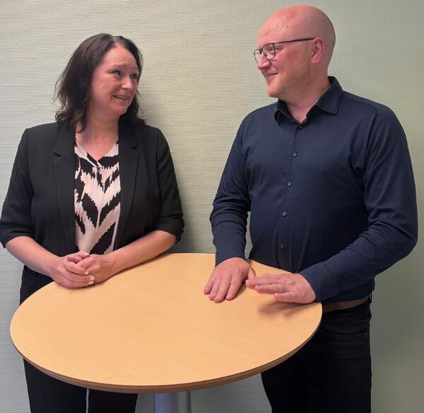 To personer står ved et bord