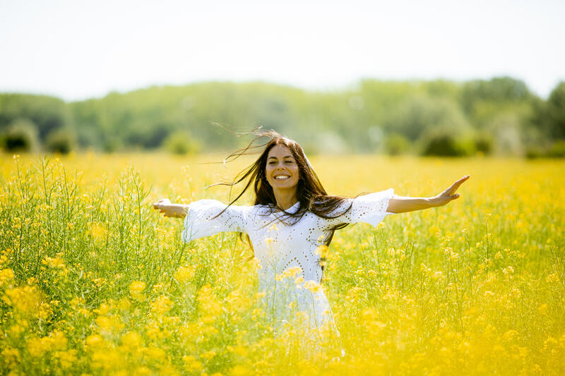 Dame som danser i en gul blomstereng