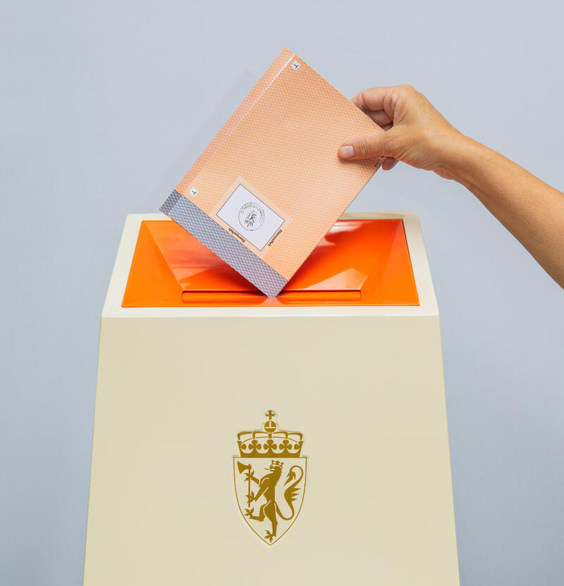 Stemmeseddel blir lagt i en valgurne