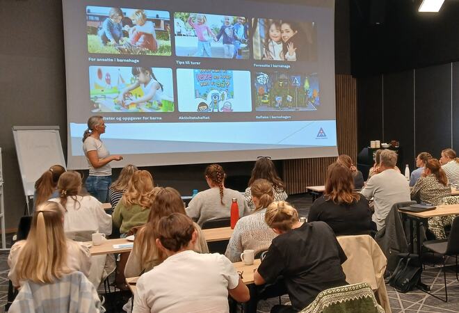 Føredrag med mange personar i salen.
