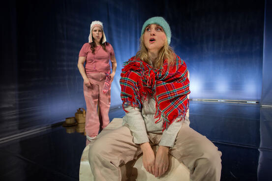 Foto fra forestillingen: To kvinner i lett samiskinspirerte klær.