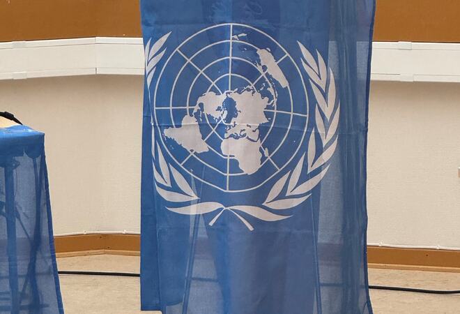 Bilde av talerstolen i kommunestyresalen med FN-flagget over